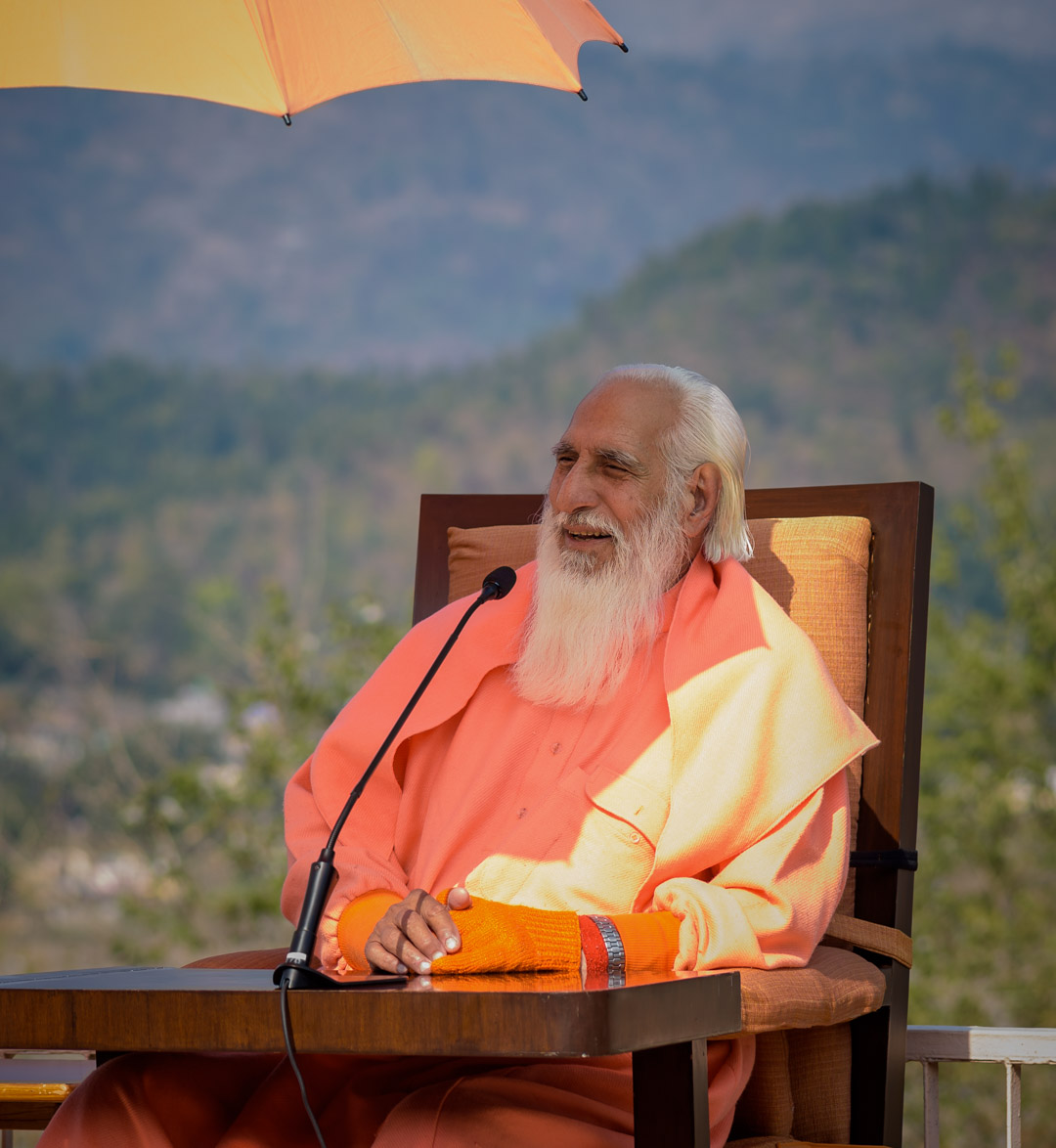 Close up of Swamiji with orange umbrella overhead